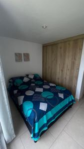 伊瓦格Hermoso Apartamento en exclusiva zona ibague Calambeo的一间卧室配有一张带蓝色棉被的床