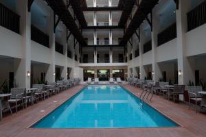 MatiAdelina Hotel and Suites的一座带桌椅的室内游泳池