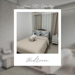 卡加盐德奥罗Uptown CDO Staycation的一张卧室的照片,卧室里设有一张床和一个标志