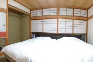东京眺めのいい一軒家的卧室配有白色的床和窗户。