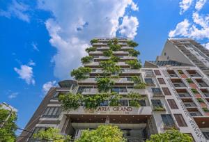 岘港Aria Grand Hotel & Spa的一座高大的公寓楼,上面有读过宏伟的标牌