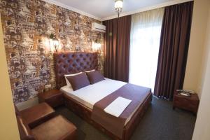 沃罗涅什Hotel Marton Business的一间卧室配有一张床和一张带照片的墙壁