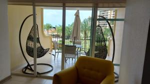 巴亚尔塔港Paradise apartment, private beach condo Bay View Grand的一间带黄色沙发的客厅和一个阳台