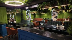 努库斯PANA HOTEL的餐厅拥有绿色的墙壁和桌椅