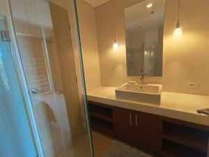 纳苏格布Luxurious Family Room Pico de Loro的浴室配有盥洗盆和带镜子的淋浴