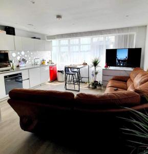 伯恩茅斯Luxury 1 bed apartment-sea view的一间带棕色沙发的客厅和一间厨房