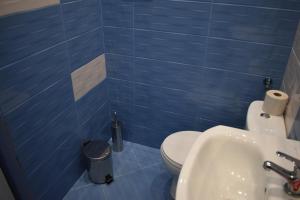 索非亚Apartment Airport Sofia的蓝色瓷砖浴室设有卫生间和水槽