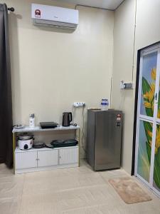 Kota BharuSafiyya Homestay的客房内设有带炉灶和冰箱的厨房