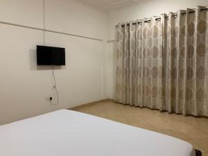 库马西Cozy One Bedroom Apartment near KNUST & CCC的一间卧室配有一张床和一台平面电视