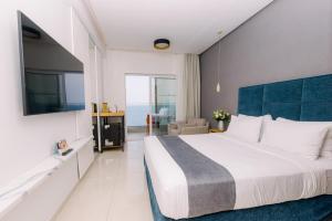 帕拉马Ray Hotel Corfu的一间卧室配有一张大床和蓝色床头板