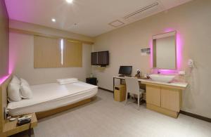 釜山Nampo Comma Hotel的酒店客房设有床、水槽和镜子
