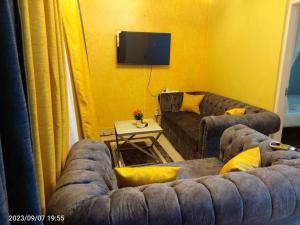 基苏木Wusiiza Homestay Kisumu的带沙发和电视的客厅