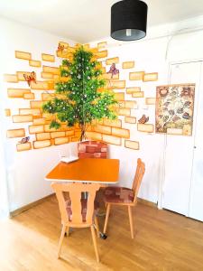 巴克乌Apartment Eminescu - A pleasant stay in Bacau的一间设有桌子的用餐室和墙上的一棵树