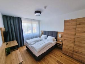 菲拉赫Mountains & Lakes - Chaletdorf的一间卧室设有一张床和一个大窗户