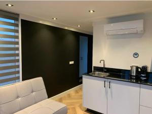泽沃德Tiny Houseboat Luxery的厨房设有黑色墙壁和白色的柜台。