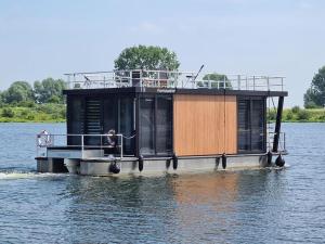 泽沃德Tiny Houseboat Luxery的湖水中的船屋