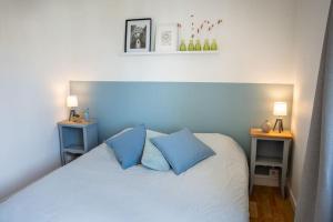 坎佩尔Les Hirondelles By Nid'Ouest的一间卧室配有白色床和蓝色枕头