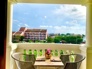 会安DE VIVRE HOI AN - Aman Boutique Hotel的阳台享有建筑景致,配有桌椅。