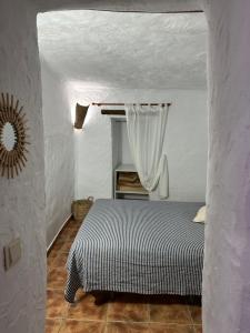 GaleraAlojamiento Cuevas Victoria的一间白色客房内的床铺卧室