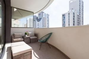 瓦伦西亚Precioso apartamento en residencial con piscina的大楼内的阳台配有长凳和椅子