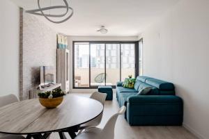 瓦伦西亚Precioso apartamento en residencial con piscina的客厅配有蓝色的沙发和桌子