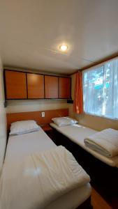 切里亚莱Camping Bella Vista的小型客房 - 带2张床和窗户