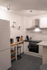 弗莱堡Ferienwohnung Naturini的厨房配有白色橱柜和炉灶烤箱。