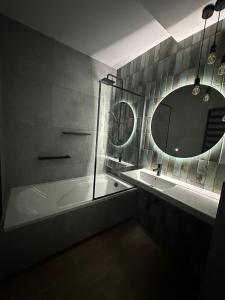 科宁Hotel Kresowianka的带浴缸、水槽和镜子的浴室
