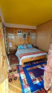 大吉岭Rambler's Nesting Homestay的卧室配有一张床铺,位于带木墙的房间内