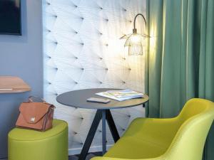 耶尔耶尔中心蔚蓝海岸美居酒店的一张桌子和两把黄色的椅子以及一张桌子和椅子