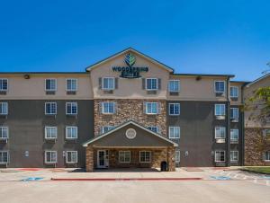 Trophy ClubWoodSpring Suites Fort Worth Trophy Club的一座大建筑,上面有标志