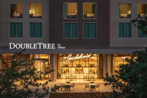 阿比林Doubletree By Hilton Abilene Downtown Convention Center的一座配有桌椅的建筑前的商店