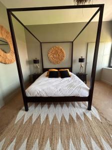 Lieu-Saint-AmandLe Manoir du Monde的一间卧室配有一张带大镜子的天蓬床