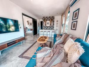 图卢姆Naats Amigos Tulum的客厅配有蓝色的沙发和电视