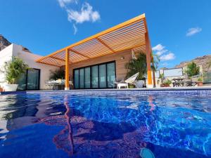 莫甘Villa de lujo con piscina climatizada的房屋前的游泳池