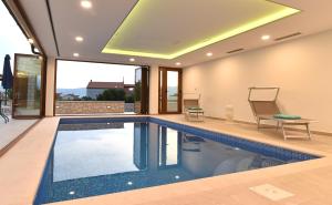 克尔克Villa Muskatel -with heated pool的一座带天花板的房屋内的游泳池