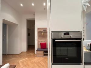 维也纳Apartment with garden - central station的厨房设有白色的墙壁和炉灶。 顶部烤箱