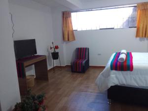 库斯科Incas Town Inn的一间卧室配有一张床、一台电视和一个窗口
