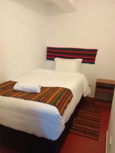 库斯科Incas Town Inn的卧室配有一张带条纹床头板的大型白色床