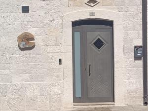 圣埃拉莫因科莱Il rifugio del folletto的砖墙边的灰色门