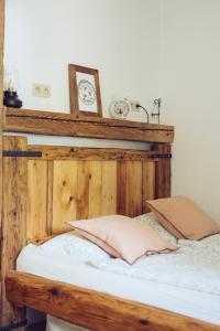 班斯卡 - 什佳夫尼察Chalúpka na konci的一张带木制床头板和墙上时钟的床