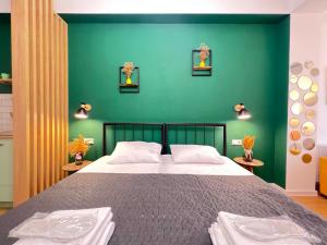 第比利斯Mohika Aparthotel的一间卧室设有一张大床和绿色的墙壁