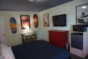 亨廷顿海滩亨廷顿冲浪酒店的一间卧室配有一张床和一台平面电视