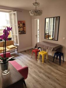 巴黎Appartement entier - Paris 12的客厅配有五颜六色的椅子和桌子