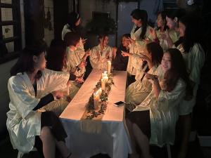 艾藻尔GIFTLAND HOMESTAY的一群坐在桌子边的女人们用蜡烛
