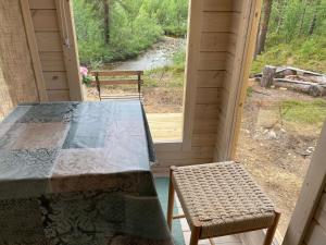 Lemmenjoki莱蒙鲁莫 - 自然体验与住宿露营地的窗户间里的一张桌子和两把椅子