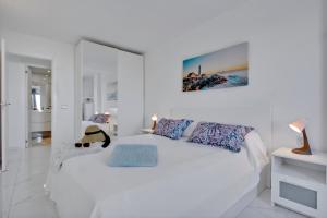 帕莱索海滩帕拉迪斯奢华公寓的白色卧室配有一张带枕头的大白色床