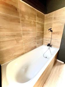 拉布雷斯Ma Montagne Chic 2的浴室设有白色浴缸,拥有木墙