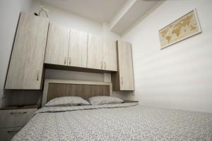 勒德乌齐AStar Apartments - SMALL的一间卧室配有一张床和木制橱柜