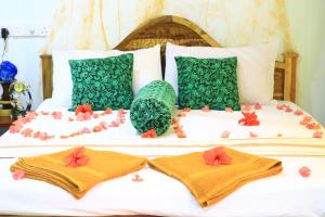 锡吉里亚Panoramic Royal Villa的一张带两条毛巾和鲜花的床